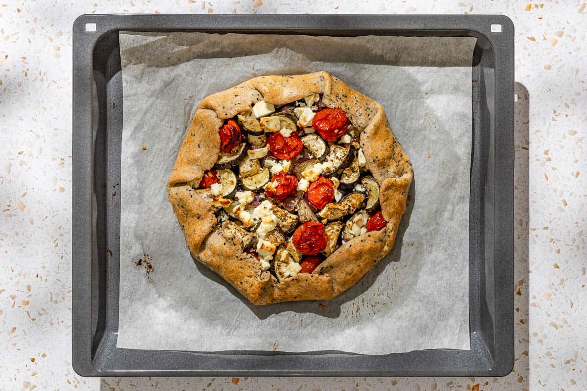 An overhead photo of the baked savory galette on a parchment lined baking sheet.