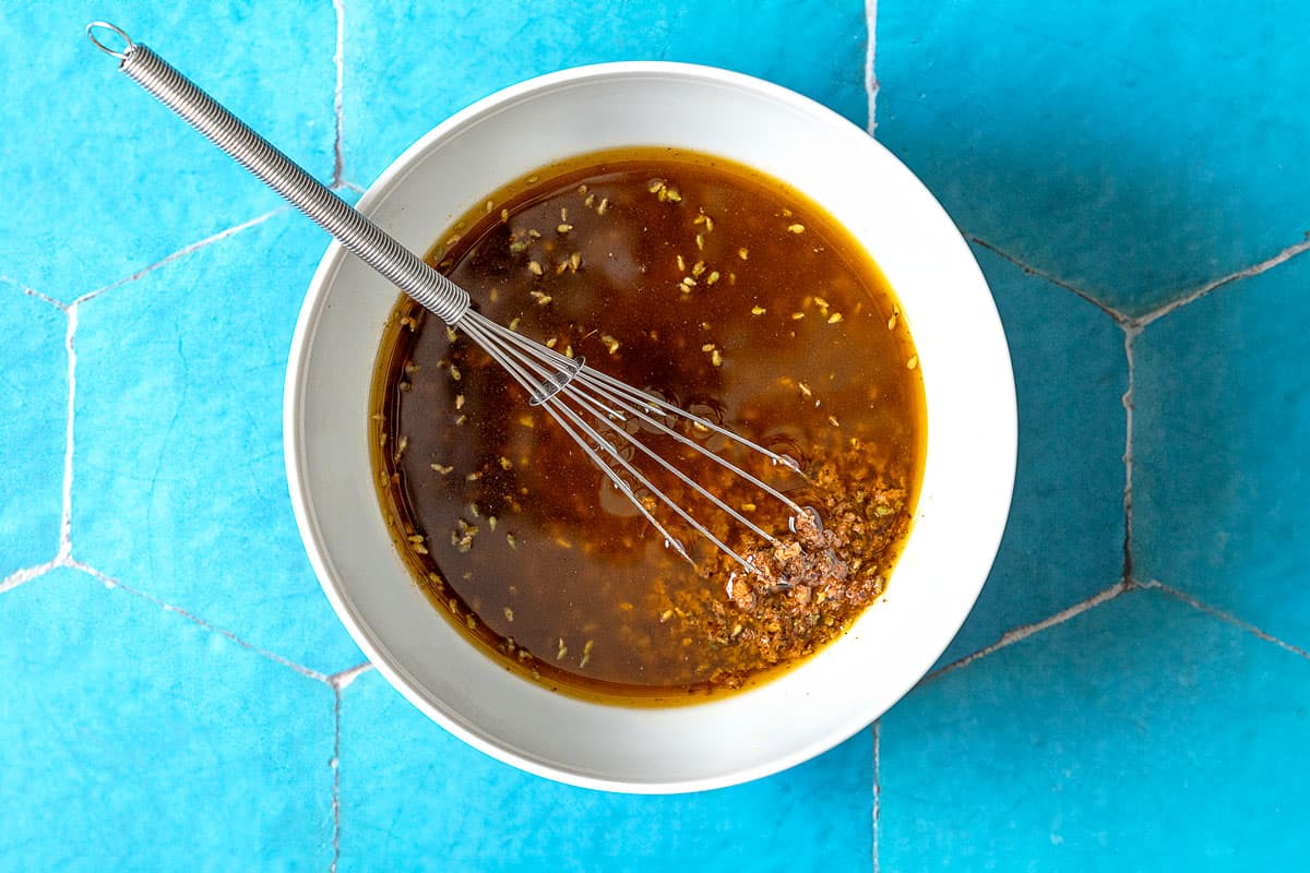 An overhead photo of za'atar garlic sauce in a bowl with a whisk.