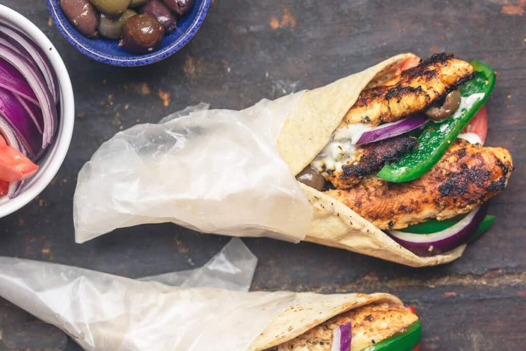 Chicken gyro wraps with tzatziki sauce, tomatoes and olives.