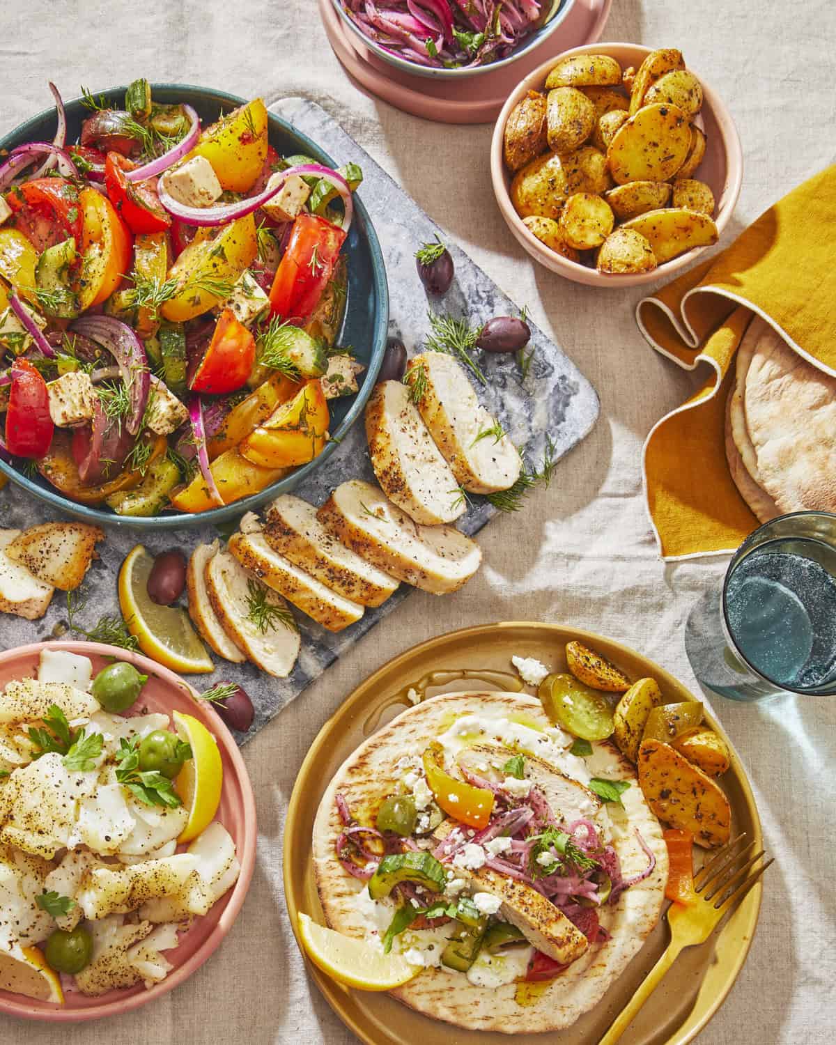 Image of Greek Gyro Bash from The Mediterranean Dish: Simply Dinner Cookbook featuring several plates of items used to make the perfect Gyro