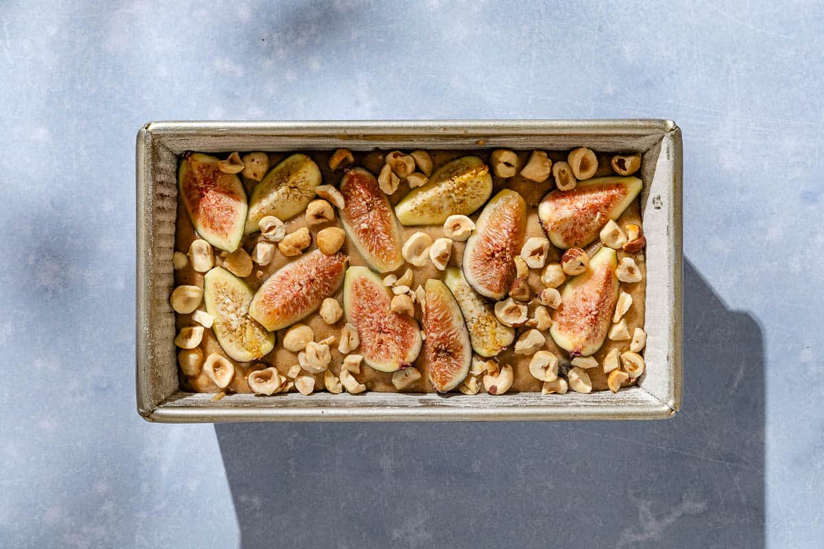 An overhead photo of the batter for the whole wheat fig bread in a loaf pan.