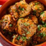 A close up of Spanish meatballs in a small bowl.