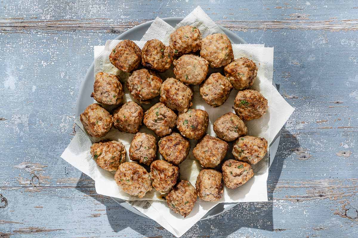 An overhead photo of Spanish meatballs on a plate lined with paper towels.