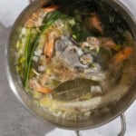 An overhead photo of all of the ingredients for the seafood stock simmering together in a large pot.