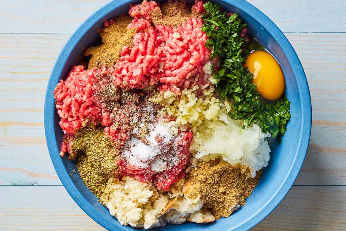 The ingredients for the meatballs in a large bowl just before being mixed together.