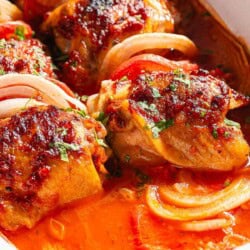 A close up of baked chicken thighs in a baking dish.