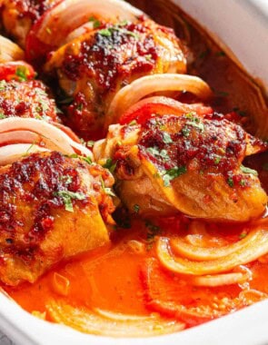 A close up of baked chicken thighs in a baking dish.