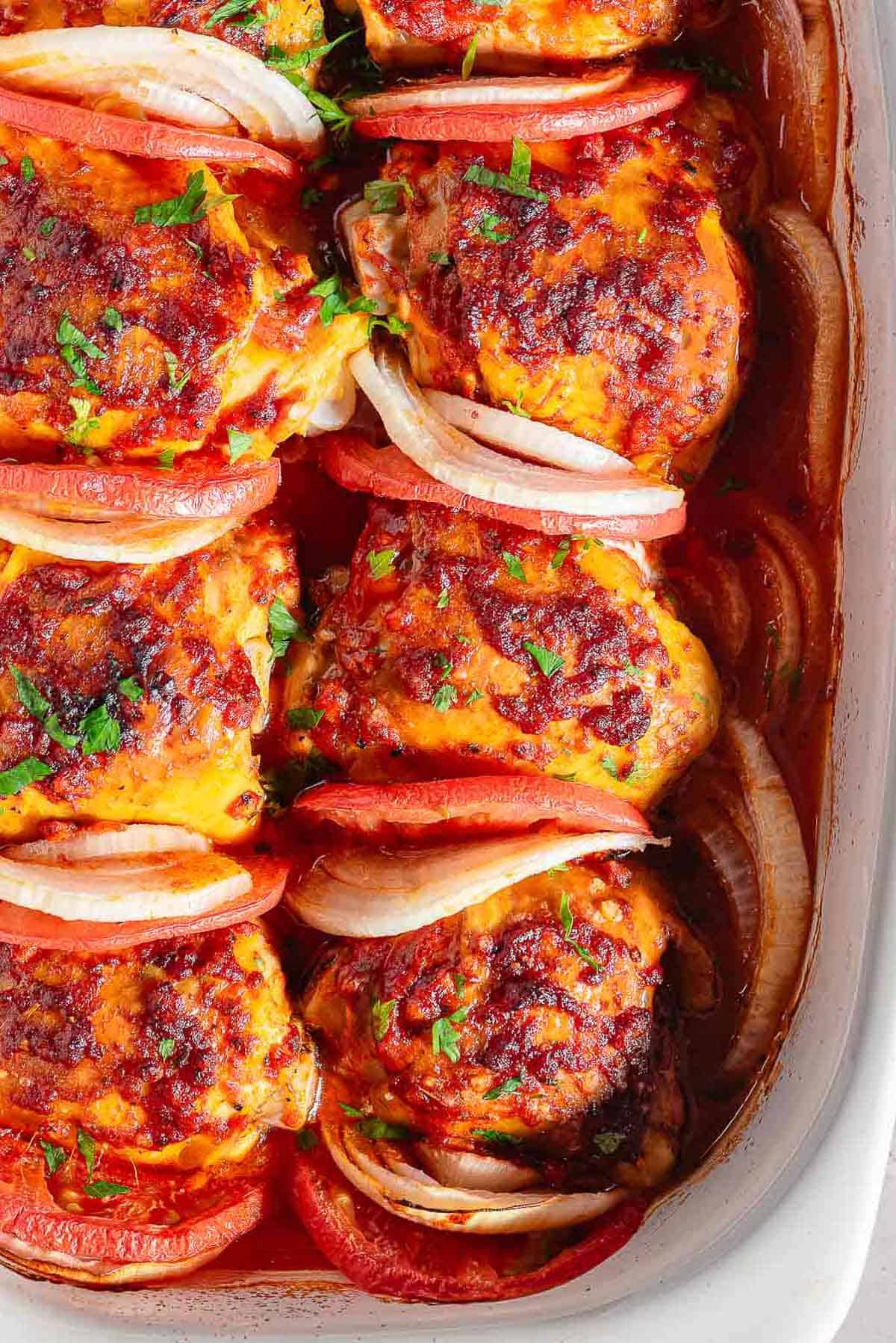 A close up of baked chicken thighs in a baking dish.