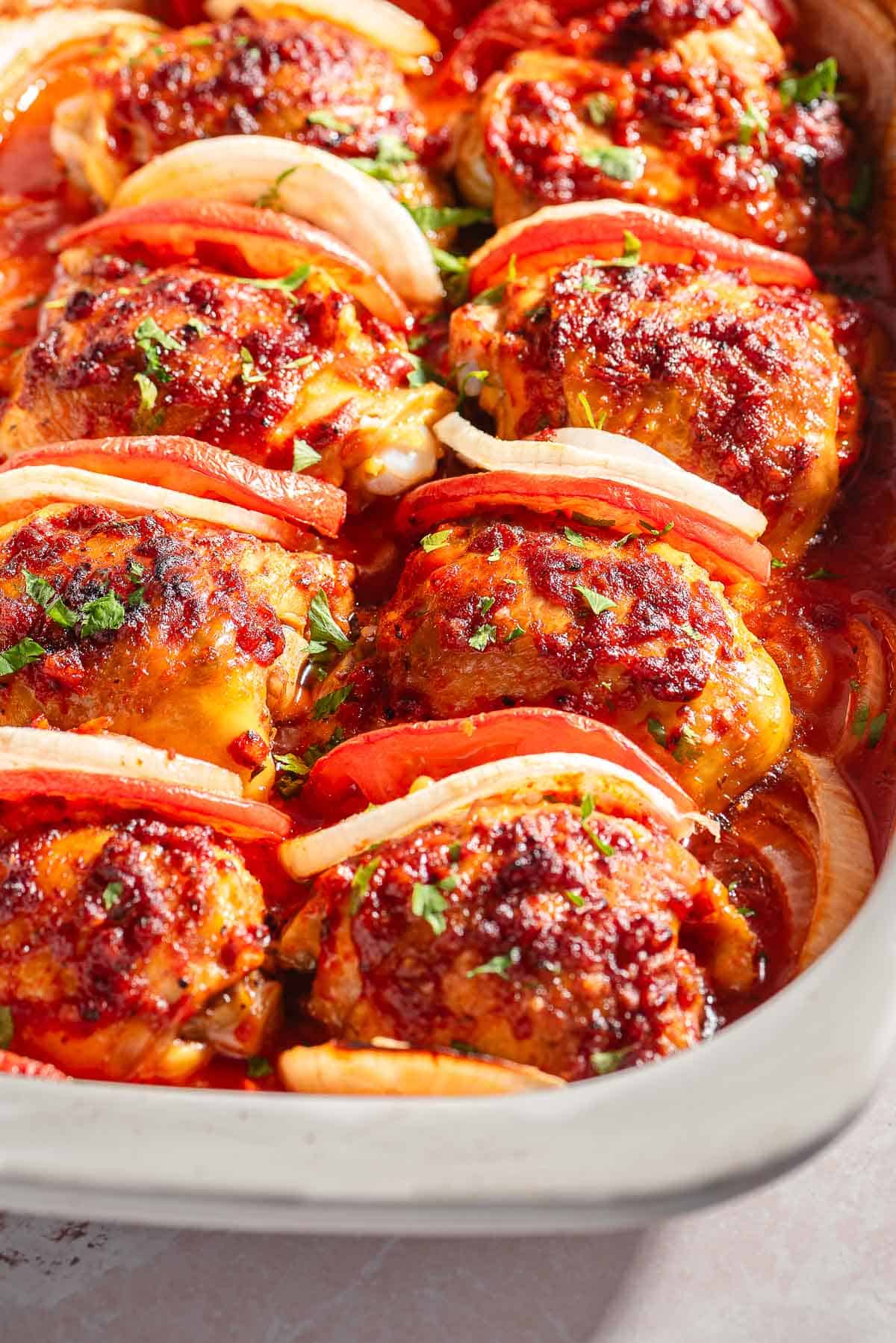 A close up of baked chicken thighs in a baking dish.