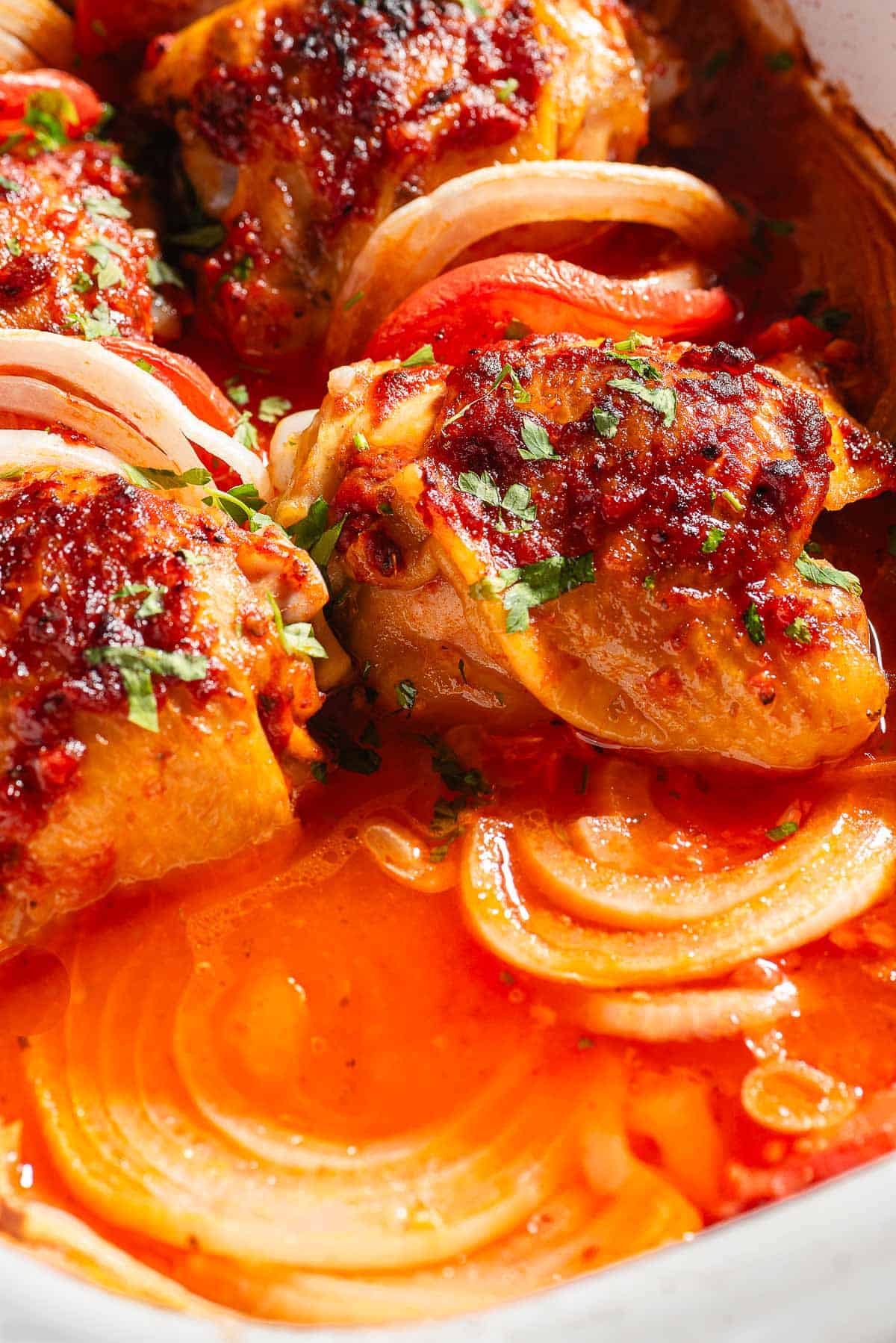 A close up of baked chicken thighs in a baking dish.