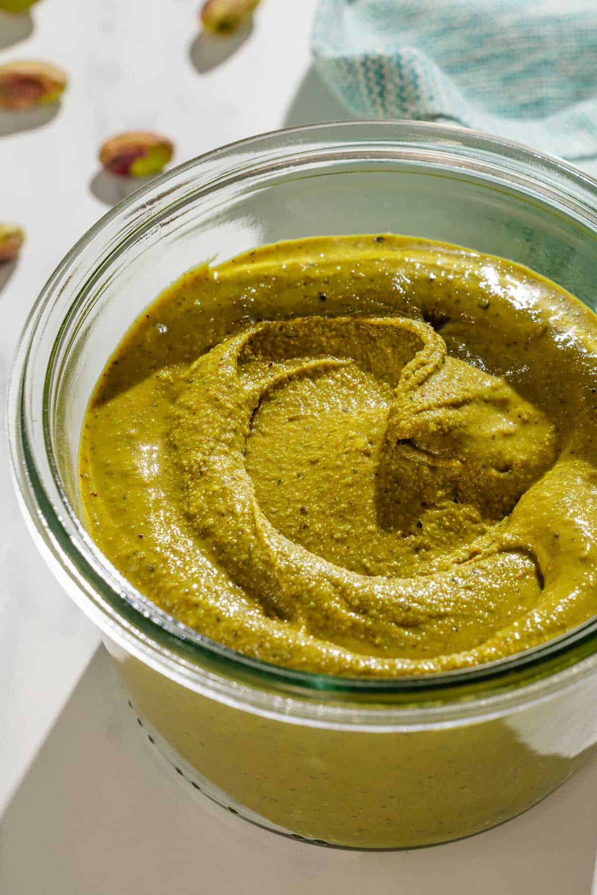 A close up of pistachio butter in a small bowls.