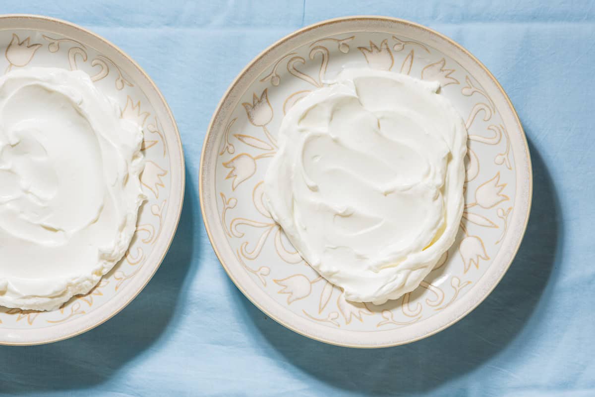 A close up of 2 bowls of greek yogurt.