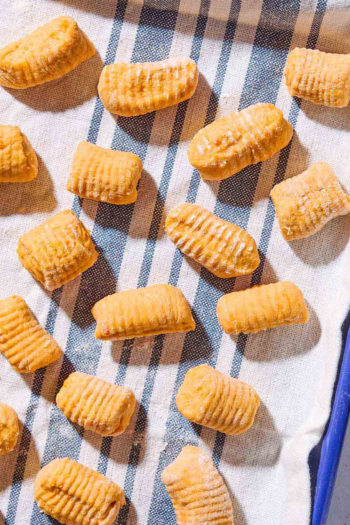 A close up of sweet potato gnocchi drying on a kitchen towel.