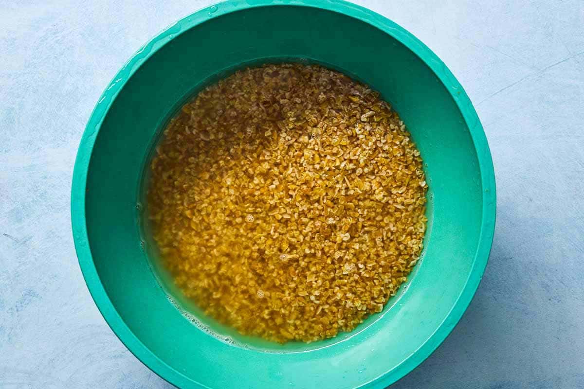 An overhead photo of freekeh soaking in a bowl of water.