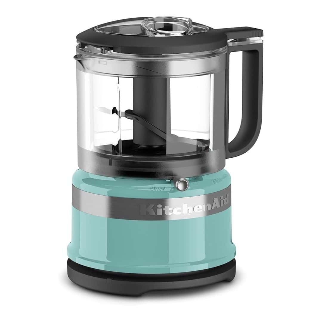 Teal KitchenAid food chopper with black and silver accents and a clear bowl. The image is floating on a white background.