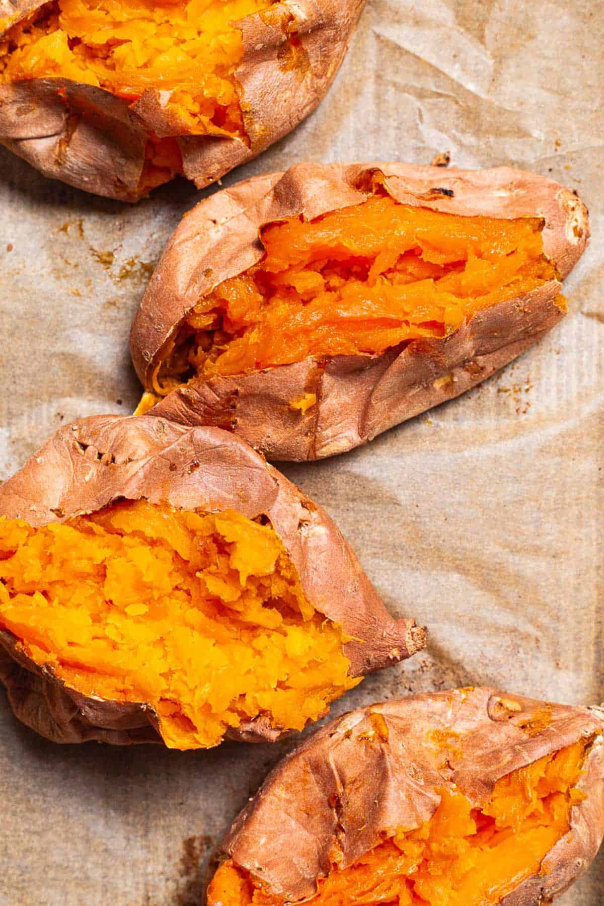 An overhead close up photo of 4 roasted sweet potatoes split open.