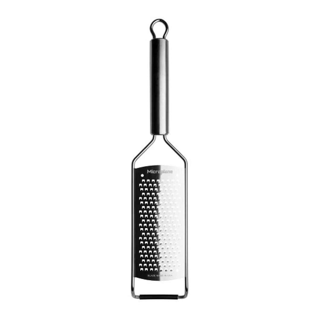 Silver microplane kitchen grater facing down with a white background.