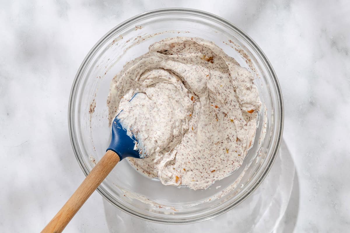 The filling for the cannolis in a bowl with a spatula.