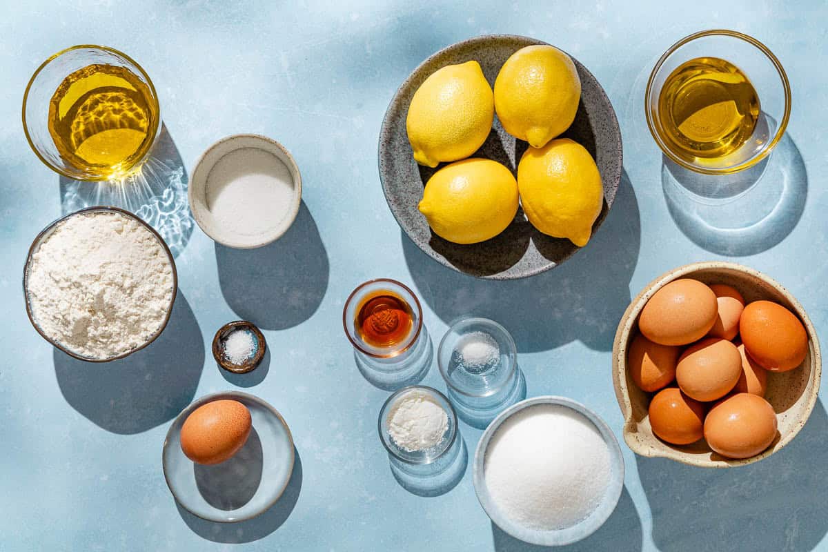 Ingredients for a lemon tart including lemons flour, sugar, salt, eggs, olive oil, cornstarch, and vanilla extract.