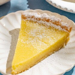 A close up of a slice of the lemon tart on a plate.