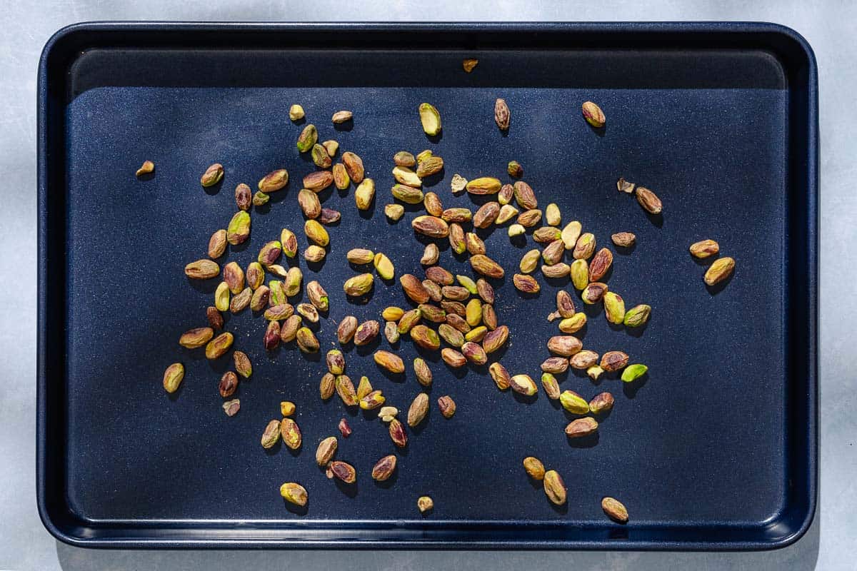 An overhead photo of pistachios spread out on a sheet pan.