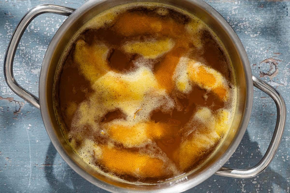 An overhead photo of the honey orange syrup simmering in a pot.