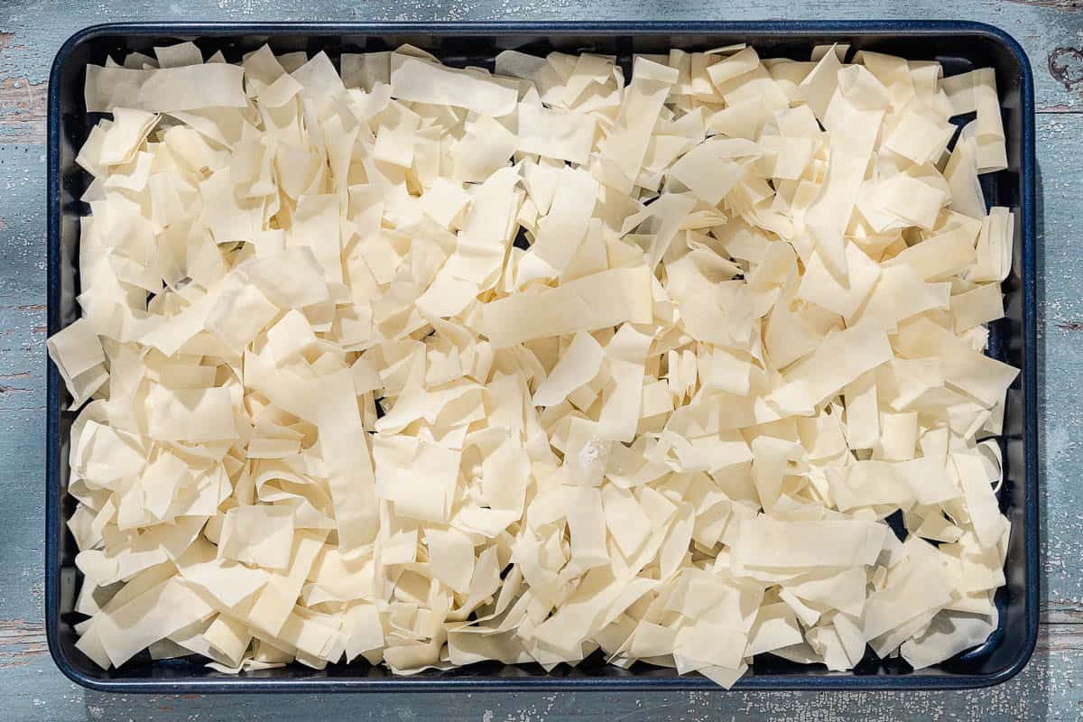 An overhead photo of slices of phyllo spread evening on a baking sheet.