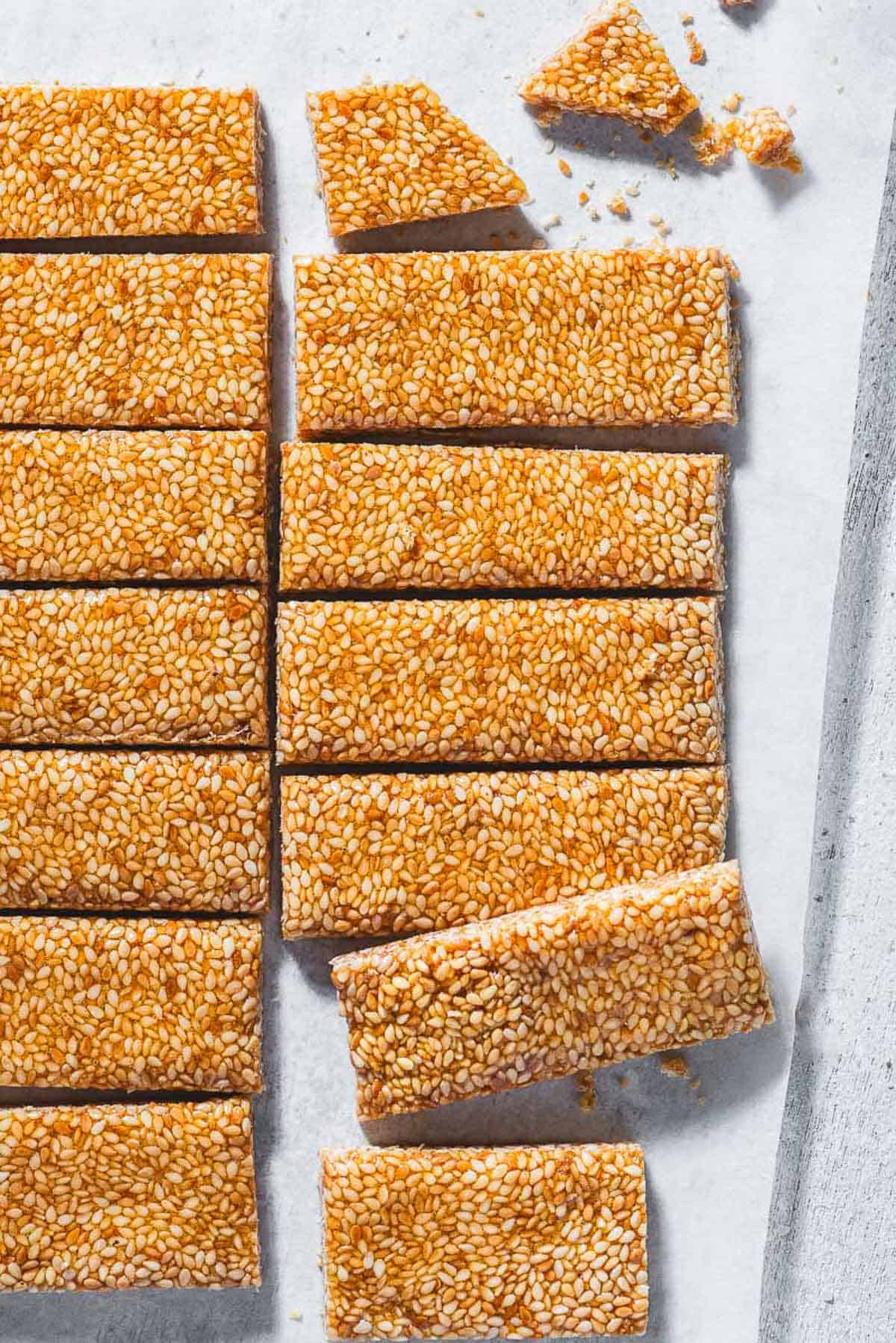 Several pieces of greek sesame candy with honey an a sheet of parchment paper.