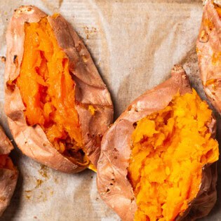 An overhead close up photo of 4 roasted sweet potatoes split open.