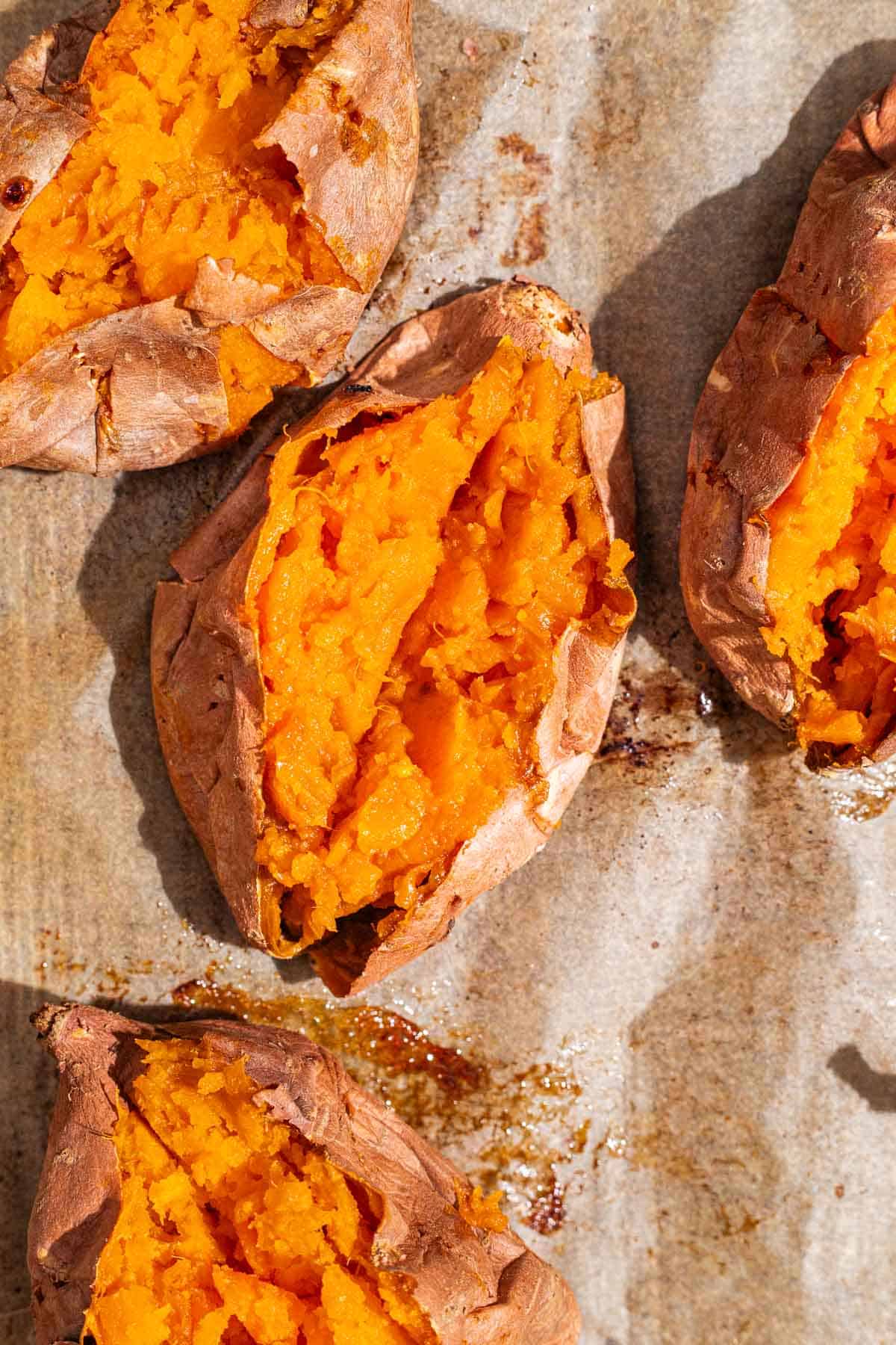 An overhead close up photo of 4 roasted sweet potatoes split open.