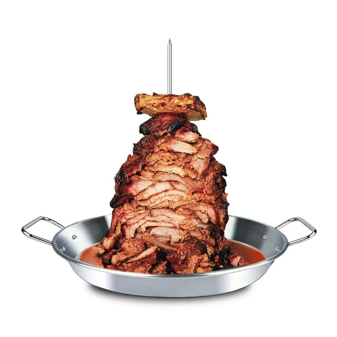 A home shawarma spit floating on a white background with skewered roast meat and pan juices collecting in the pan.