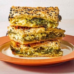 Three slices of turkish borek stacked on top of each other on a plate.