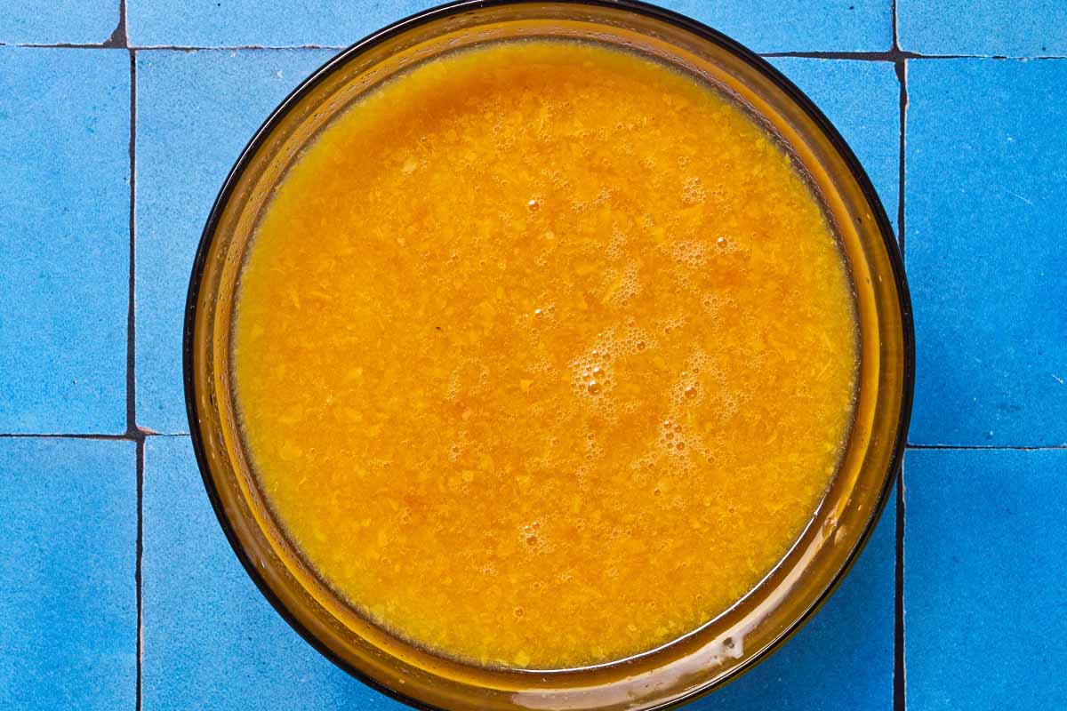 An overhead photo of dried apricots blended with water in a bowl.