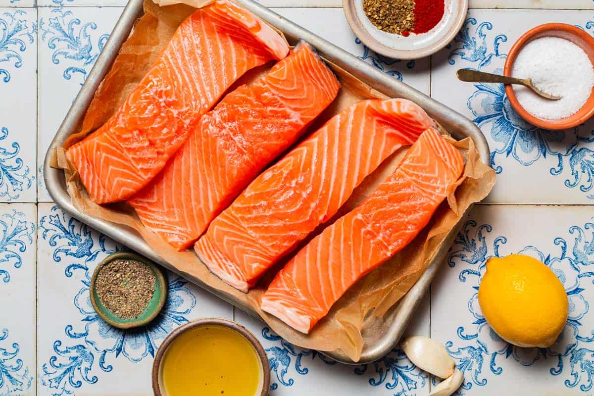 Ingredients for air fryer salmon including salmon fillets, olive oil, lemon, salt, black pepper, garlic, smoked paprika, za'atar and cumin.