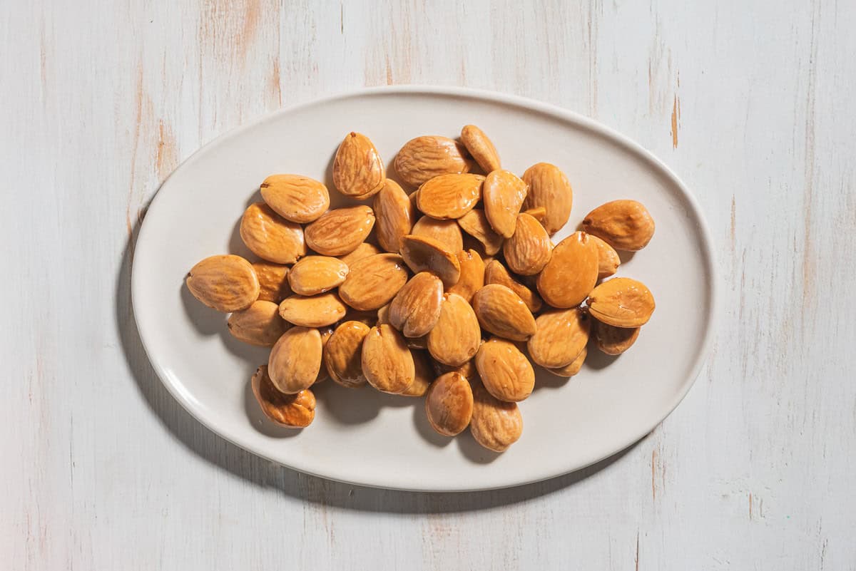 An overhead photo of toasted almonds on a plate.