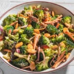 A close up of broccoli salad in a serving bowl.