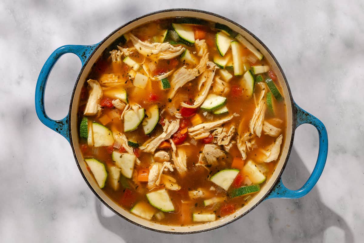 An overhead photo of chicken vegetable soup in a dutch oven.