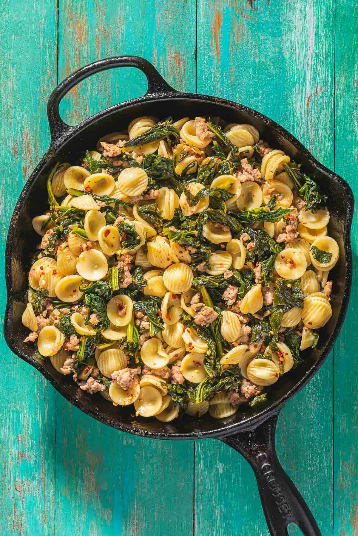 An overhead photo of orecchiette with sausage and broccoli rabe in a skillet.