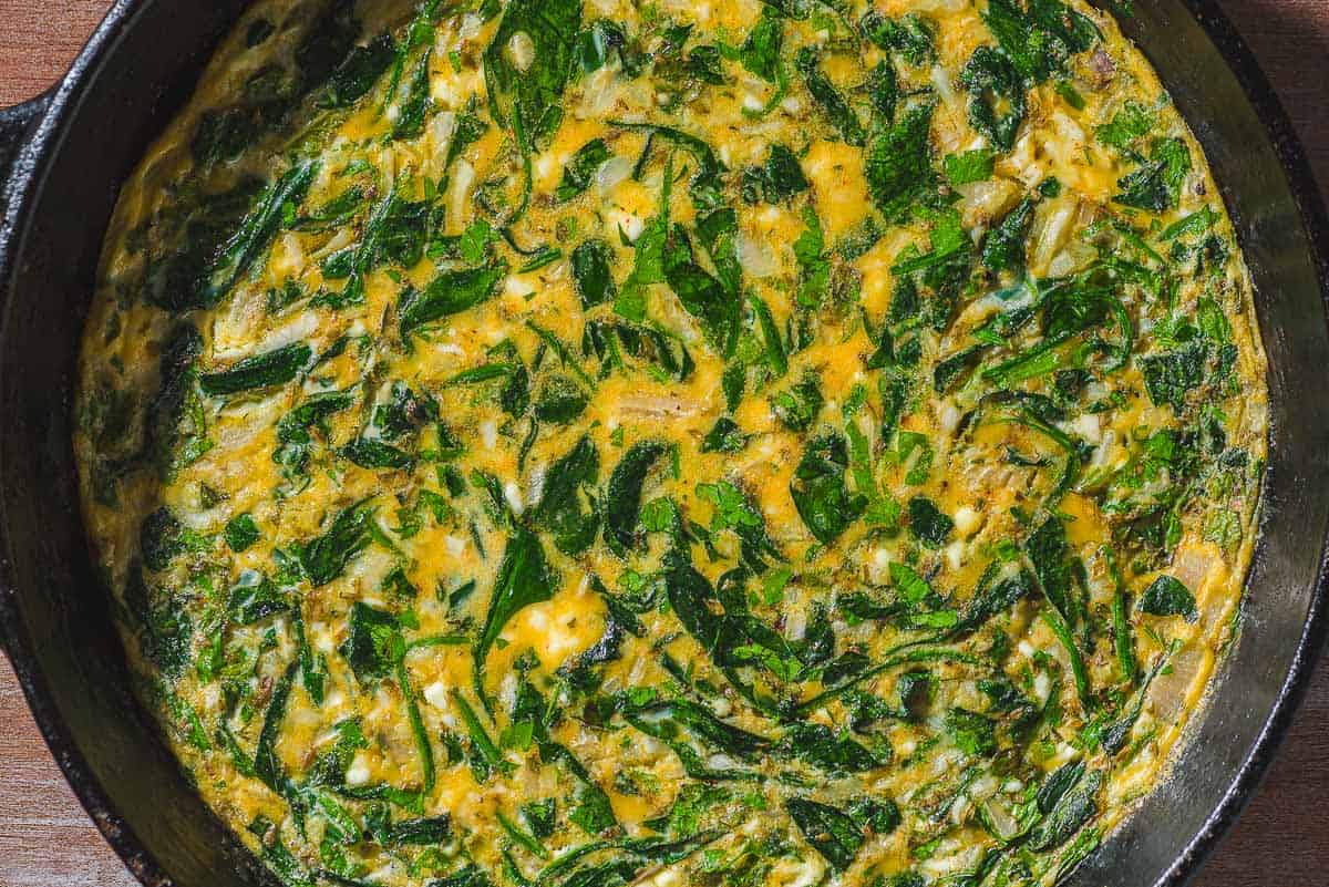 An overhead close up photo of the feta spinach frittata in a cast iron skillet.