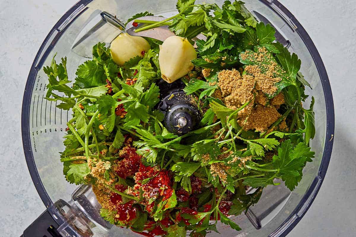 The ingredients for green chermoula just before being mixed together in the bowl of a food processor fitted with a blade.