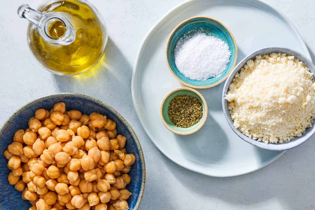 Ingredients for parmesan crisps with chickpeas and oregano including canned chickpeas, salt, oregano, and grated parmesan cheese.