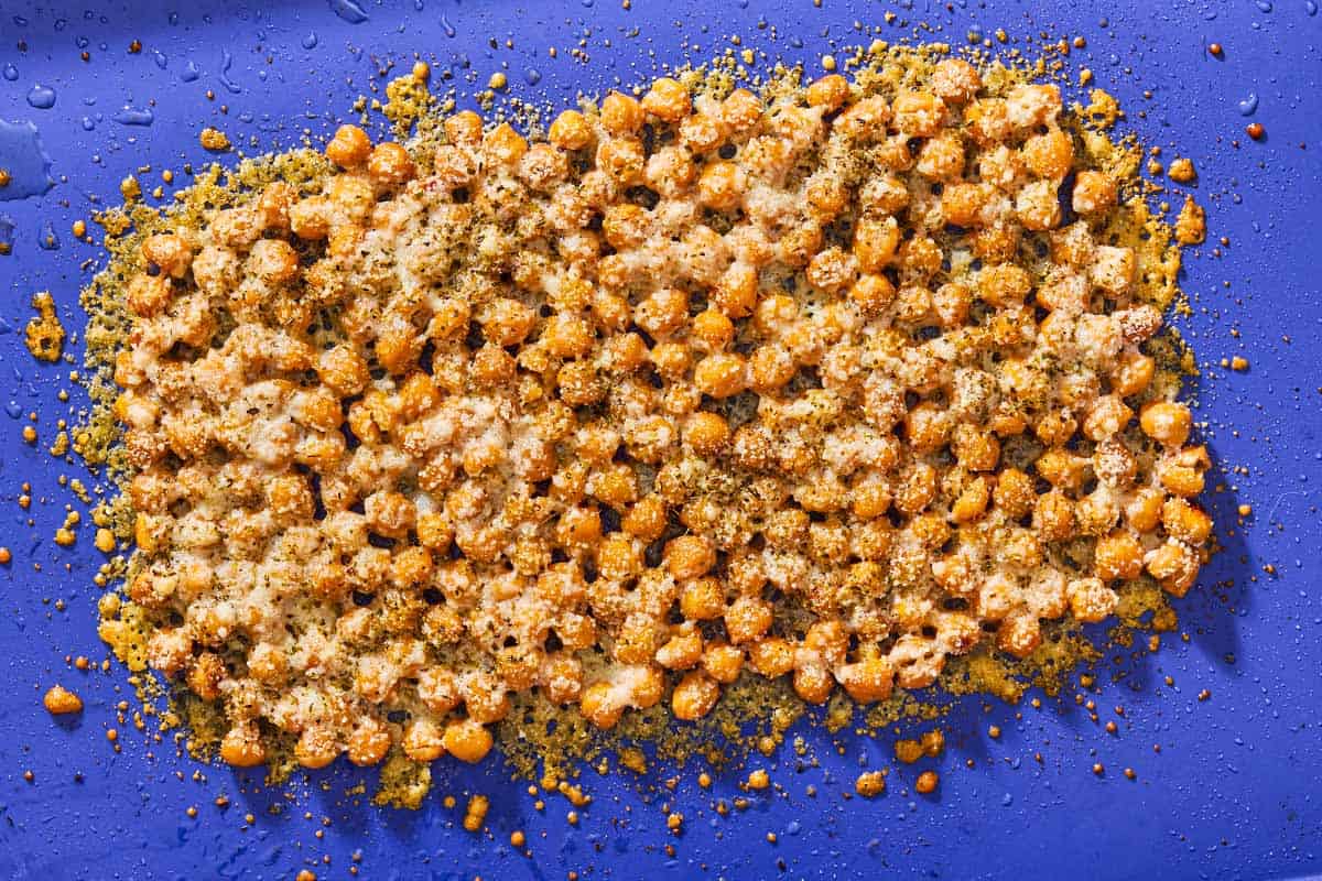 An overhead photo of a sheet baked parmesan crisps with chickpeas and oregano.