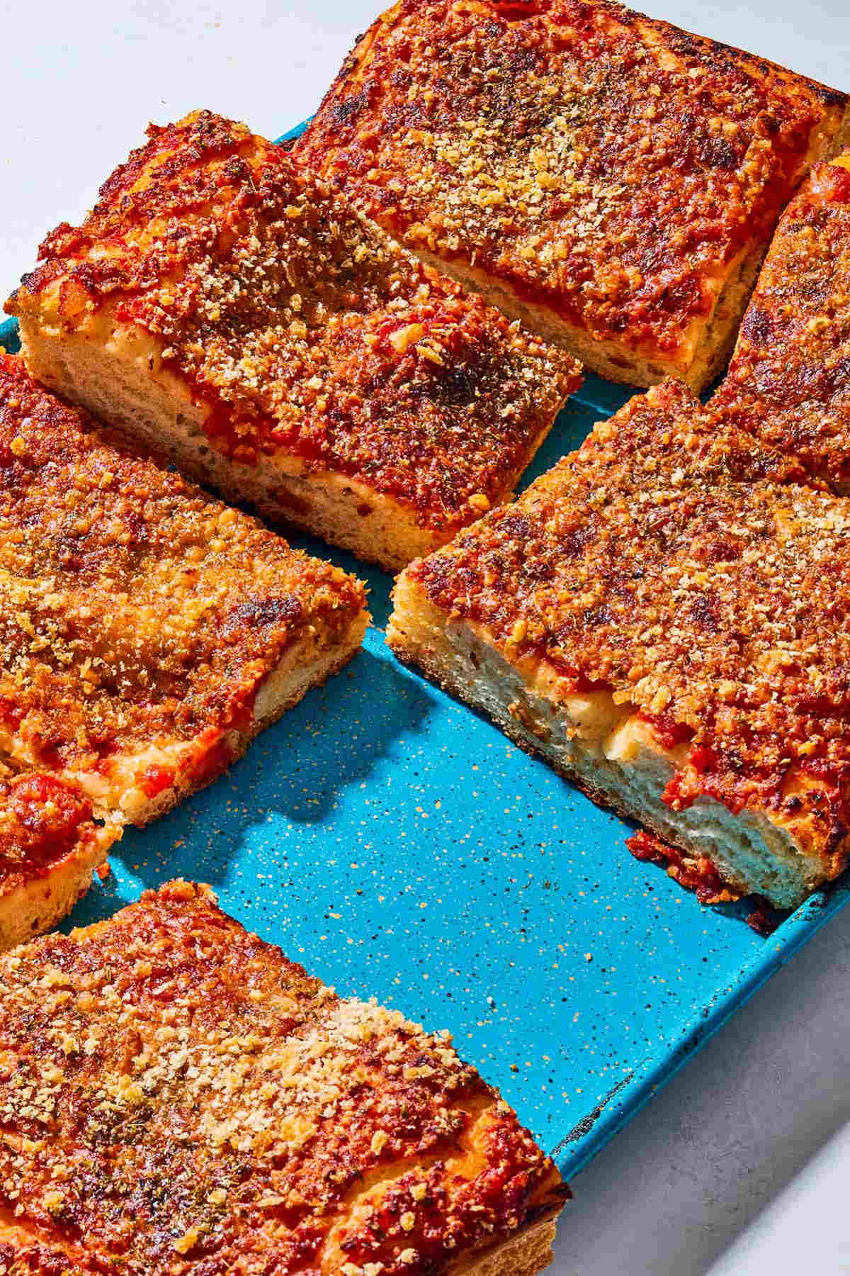 A close up of several slices of sfincione sicilian pizza on a baking sheet.