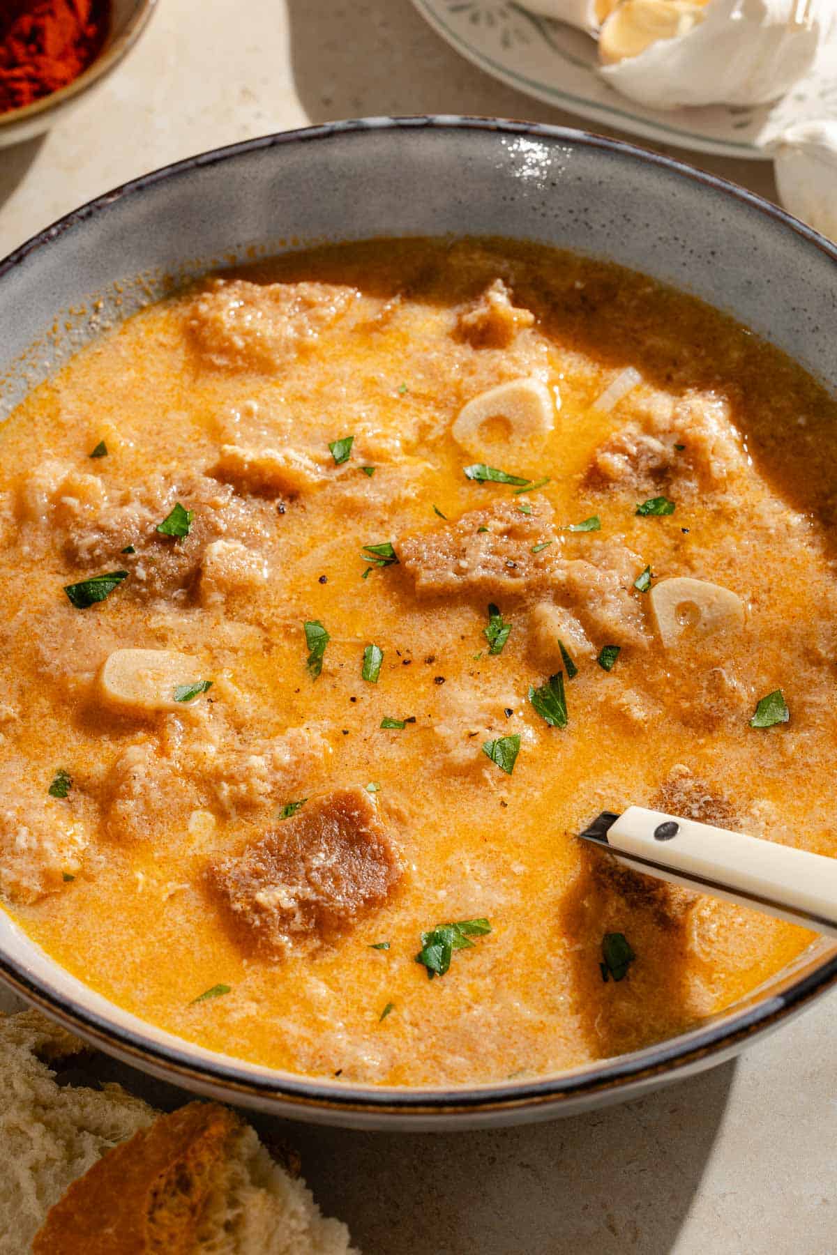 A close up of a bowl of sopa de ajo with a spoon.