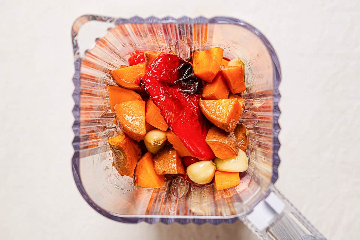 An overhead photo of the roasted vegetables for the sweet potato soup recipe in an a blender, just before being blended.