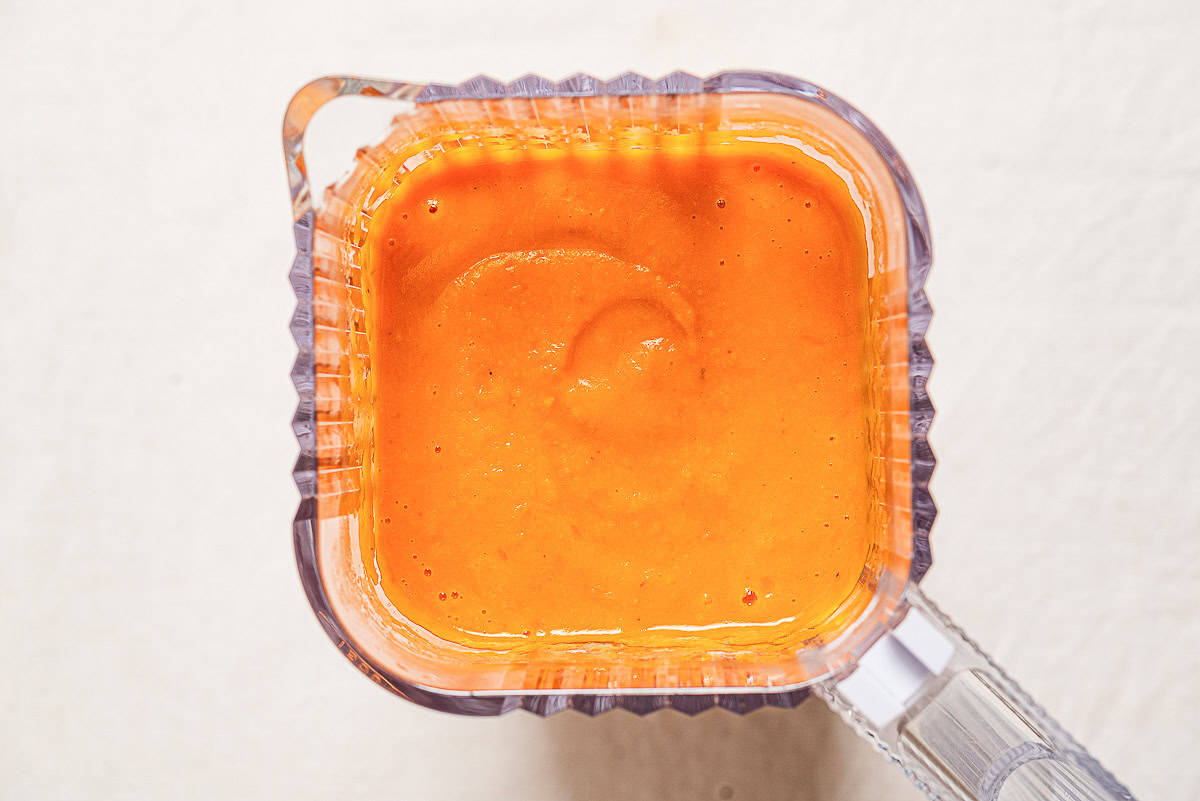 An overhead photo of the ingredients for the sweet potato soup recipe in an a blender, just after being blended.