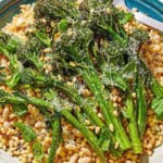 A close of up fregola sarda with broccolini on a platter with a spoon.