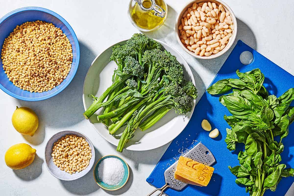 Ingredients for fregola sarda with broccolini including fregola sarda pasta, salt, broccolini, olive oil, lemons, garlic, cannellini beans, pine nuts, basil, and parmesan cheese.