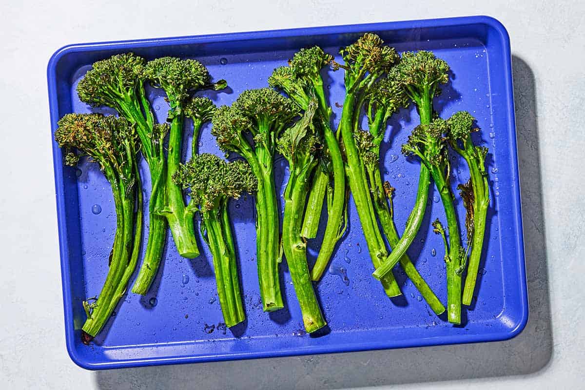 An overhead photo of cooked broccolini on a sheet pan.