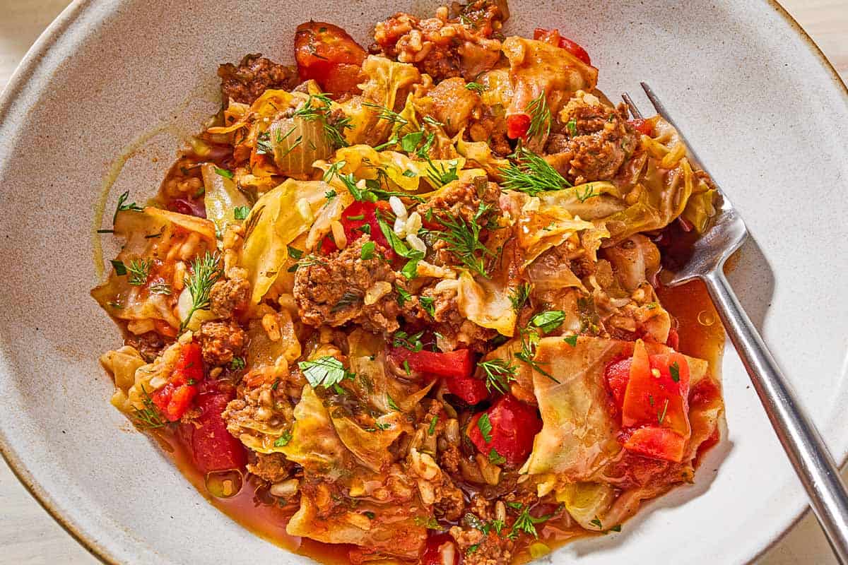 A close up of a serving of the unstuffed cabbage rolls in a bowl with a fork.